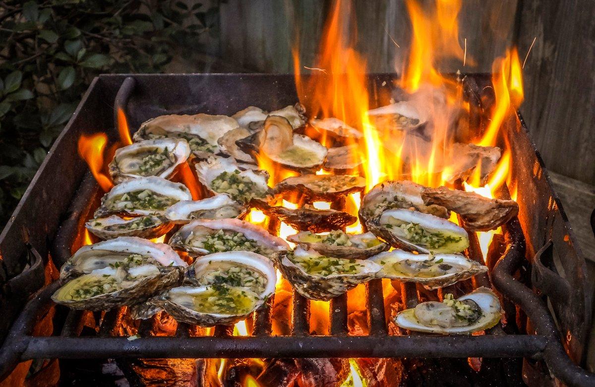 Flame-grilled oysters full of rich garlic butter and topped with shredded cheese is a classic recipe.