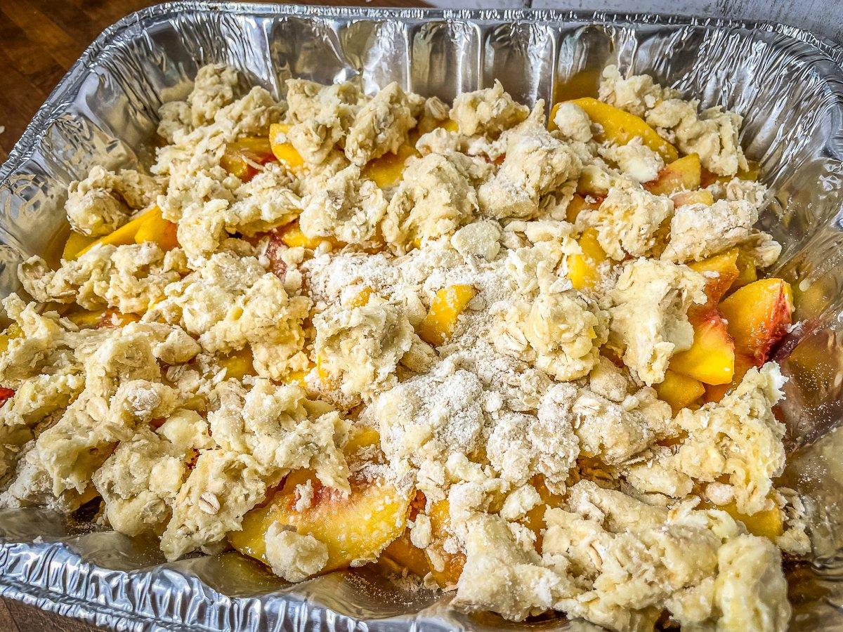 Sprinkle the topping evenly over the peach filling.