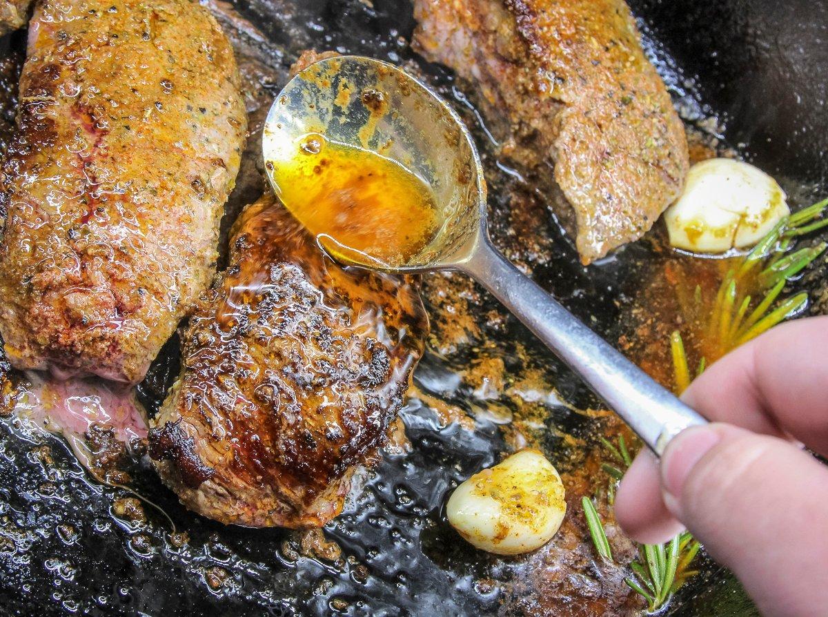 Spoon the butter over the steak to baste the meat. 