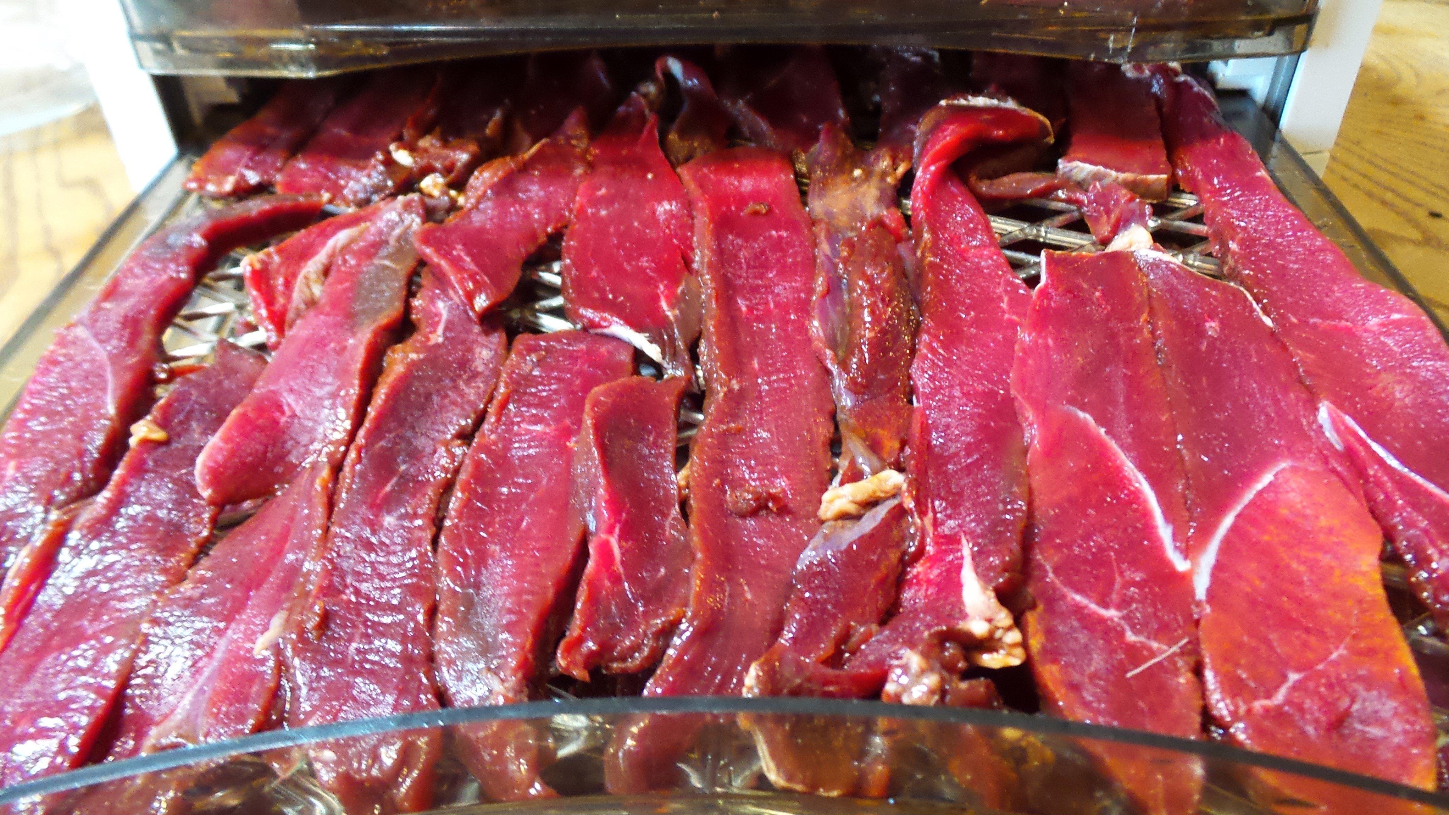 Place the sliced jerky evenly on the dehydrator trays or hang from the top rack of your oven or smoker.