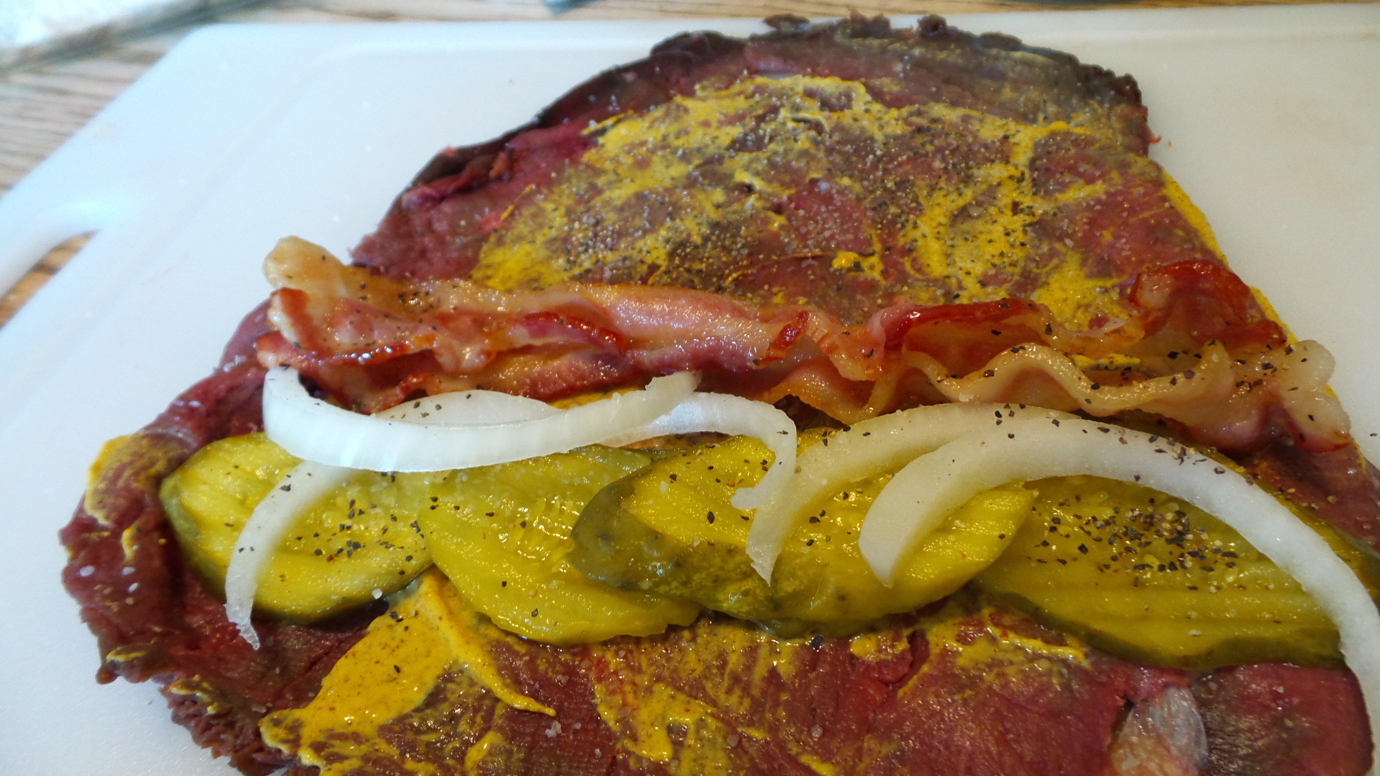 Smear brown mustard over the meat and layer on stuffing ingredients.