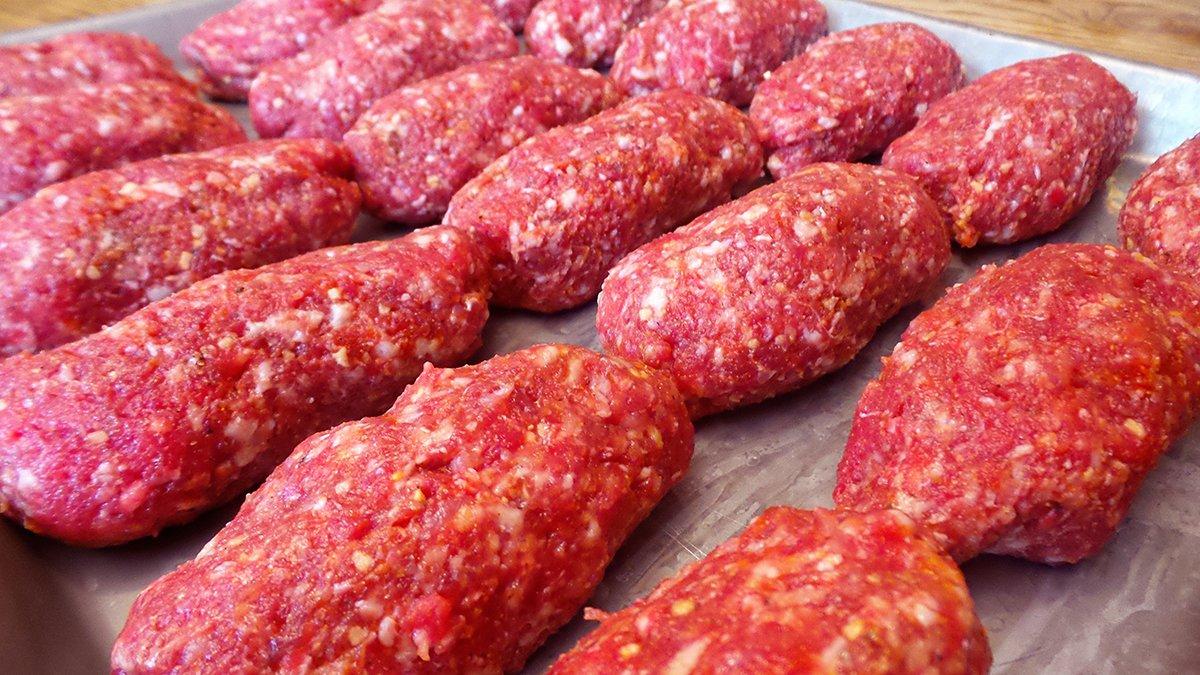 Wet hands help to keep the meat from sticking while you roll out the sausages.