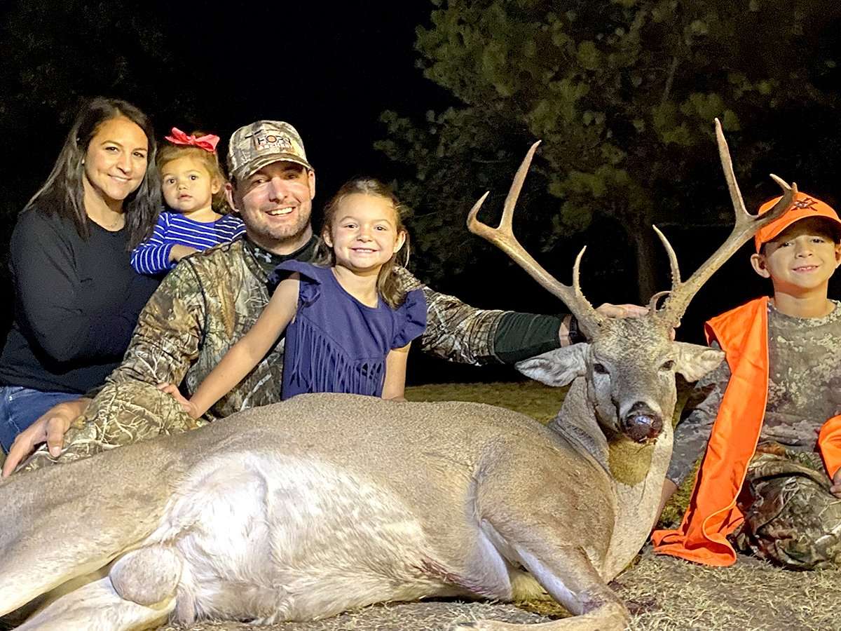 The Parrish family is all smiles behind Case Parrish's (right) old, mature buck, which his father, Trent (middle), named the Big 6. The buck was taken the evening after Trent had bow-killed a 168-1/8-inch buck. Image courtesy of Trent Parrish