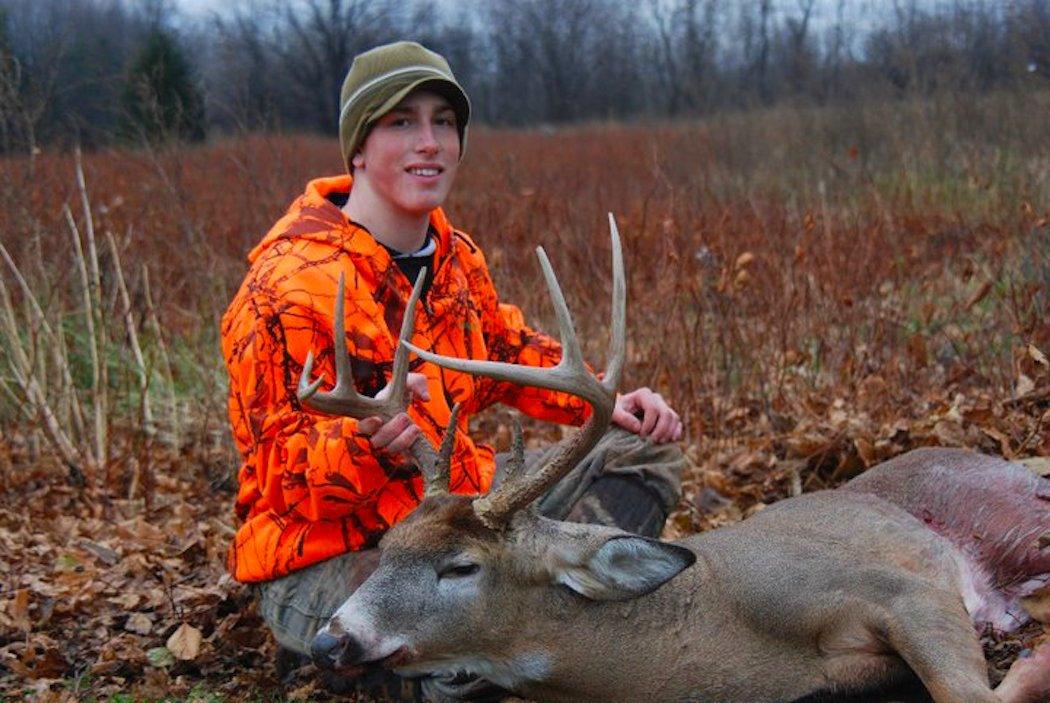 The author poses with a buck he killed with a slug gun. (Jason Reid photo)