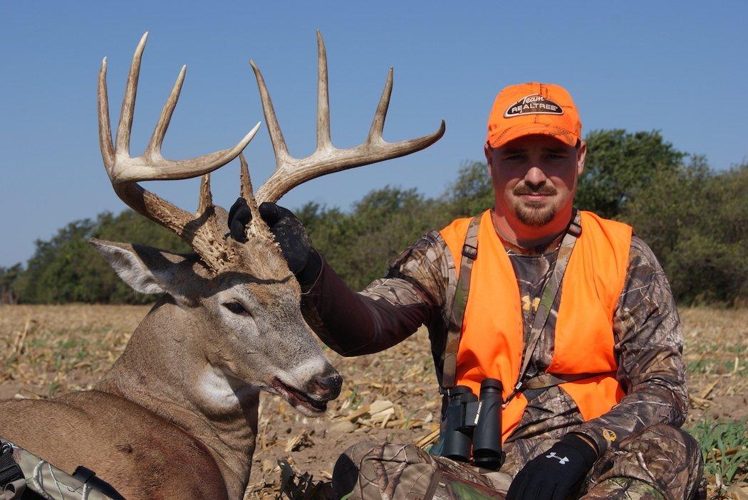 Daniel McVay of Buckventures poses with the buck he shot after crawling out into a field to get in position.