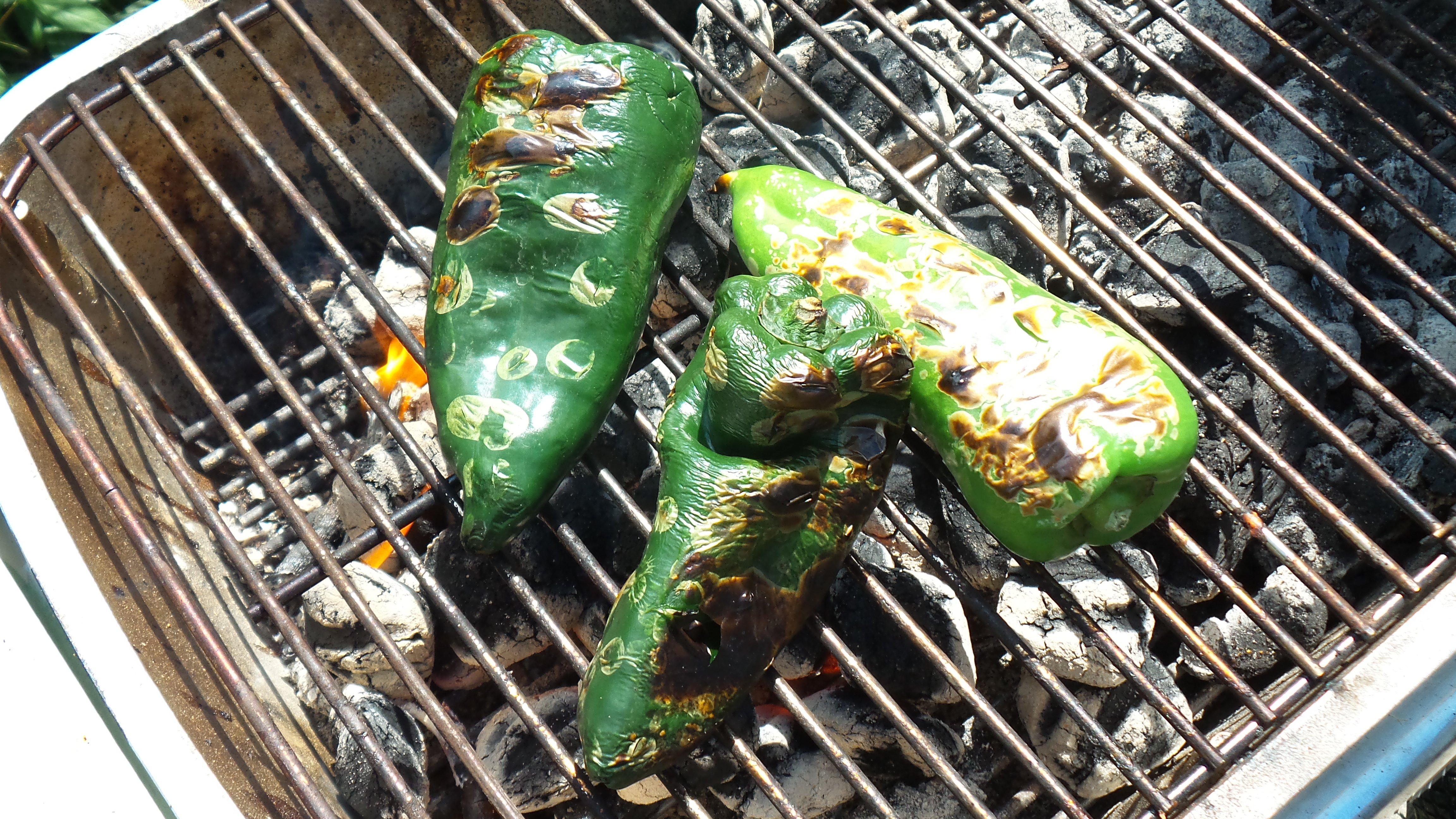 Roast the peppers over charcoal or gas flame then place in a sealed zip style bag to remove the skin.