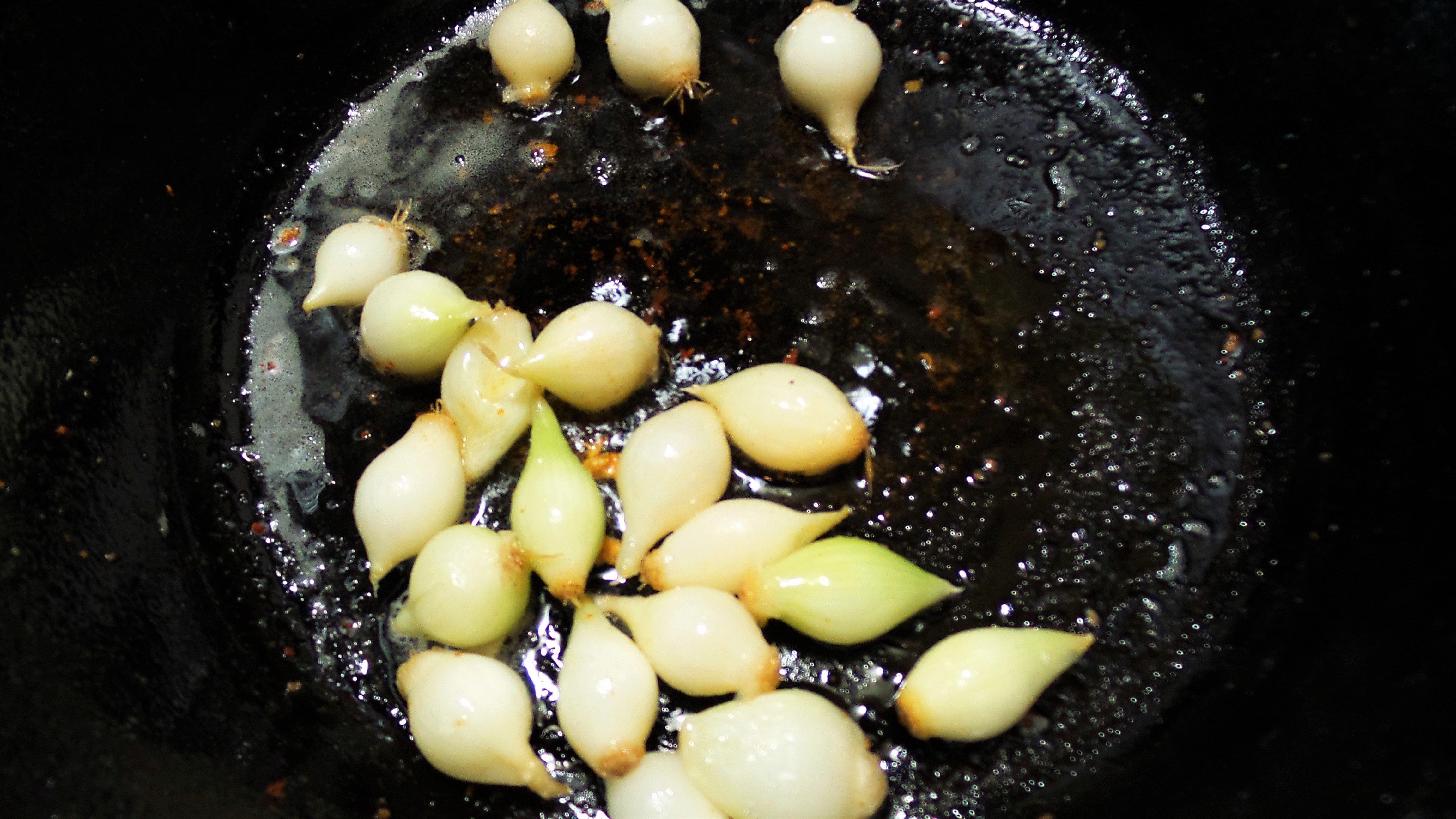 Brown the peeled onions in bacon grease.