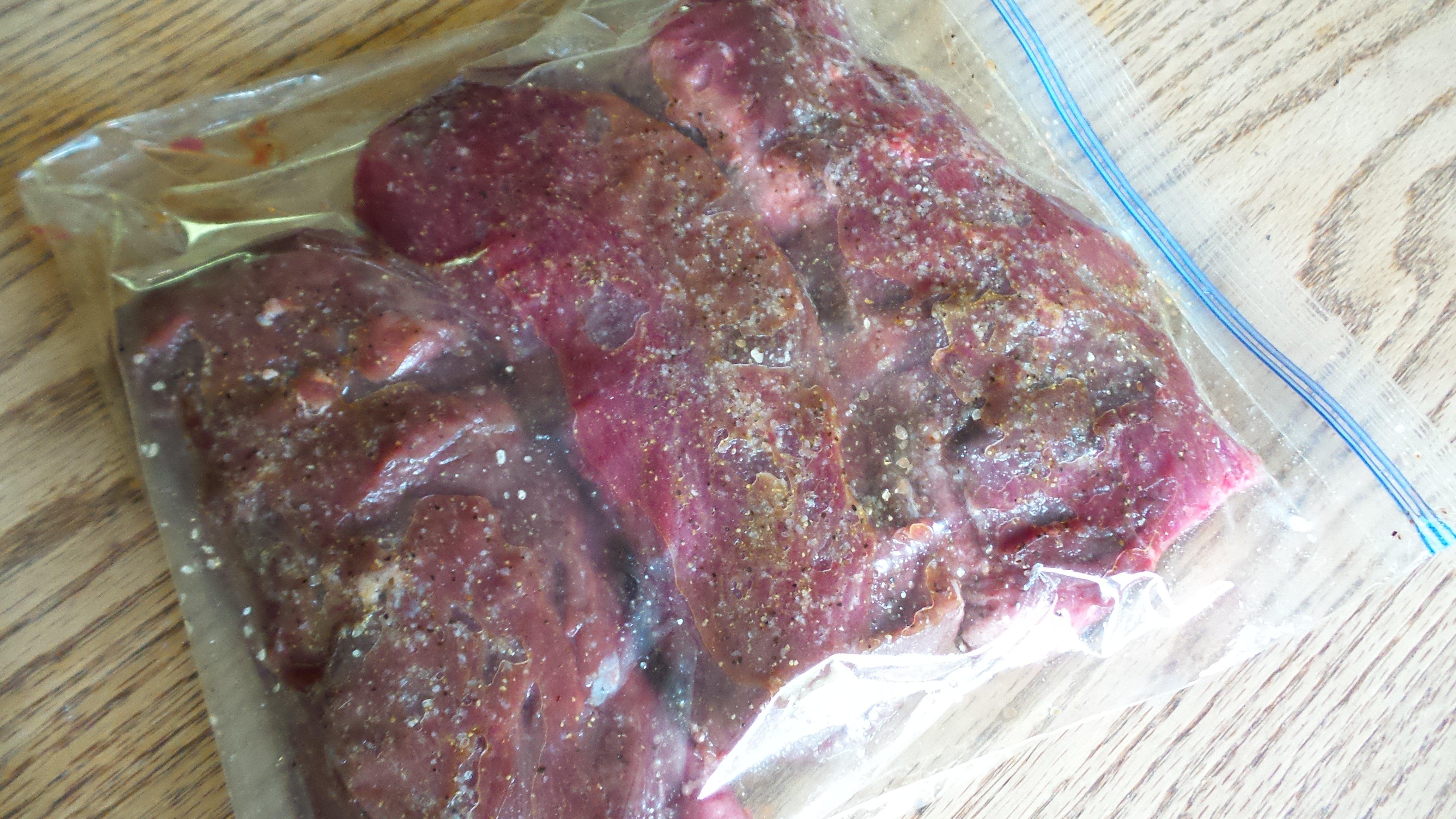 Season the backstrap and marinade at least four hours in the refrigerator.