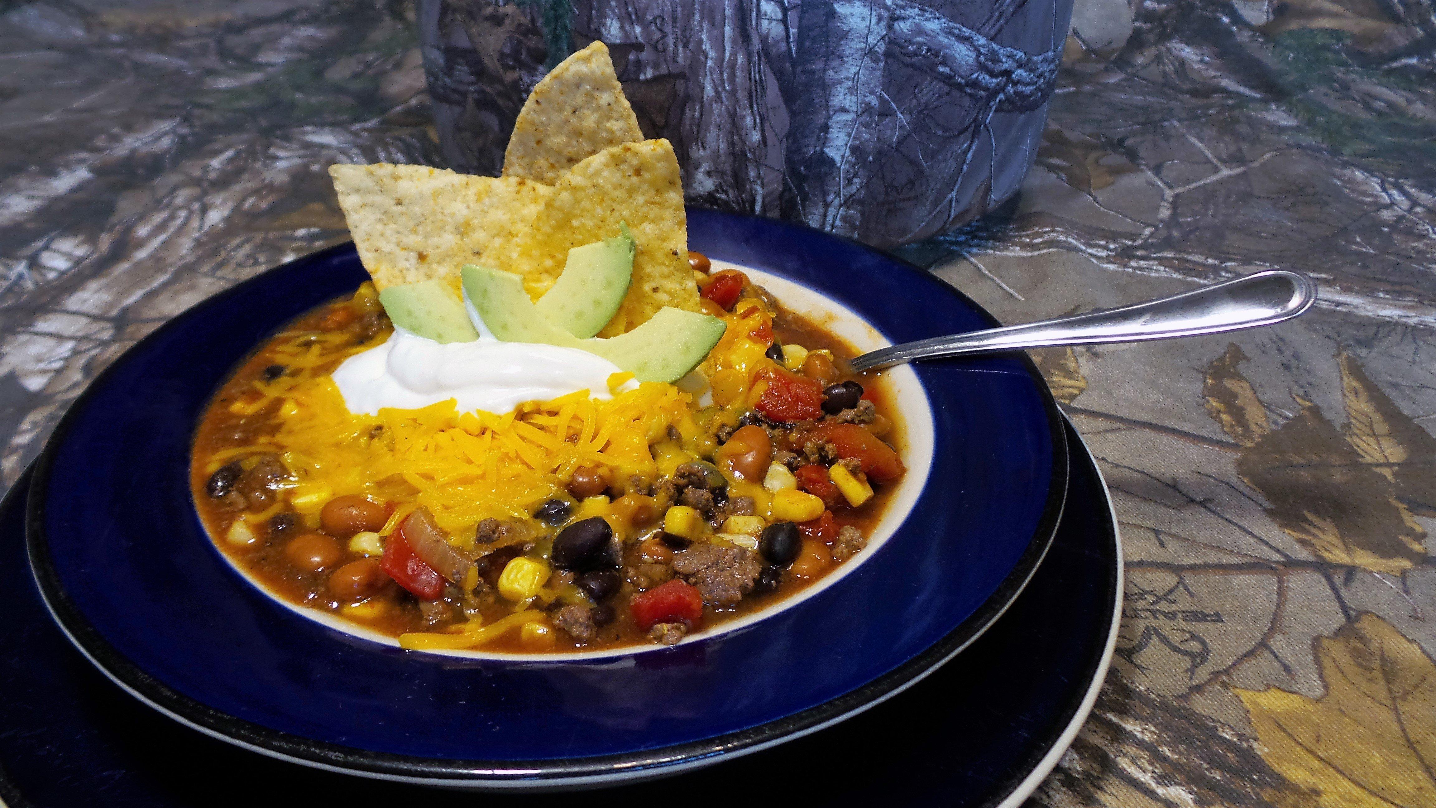 Top the soup with sour cream, avocado, and shredded cheese.