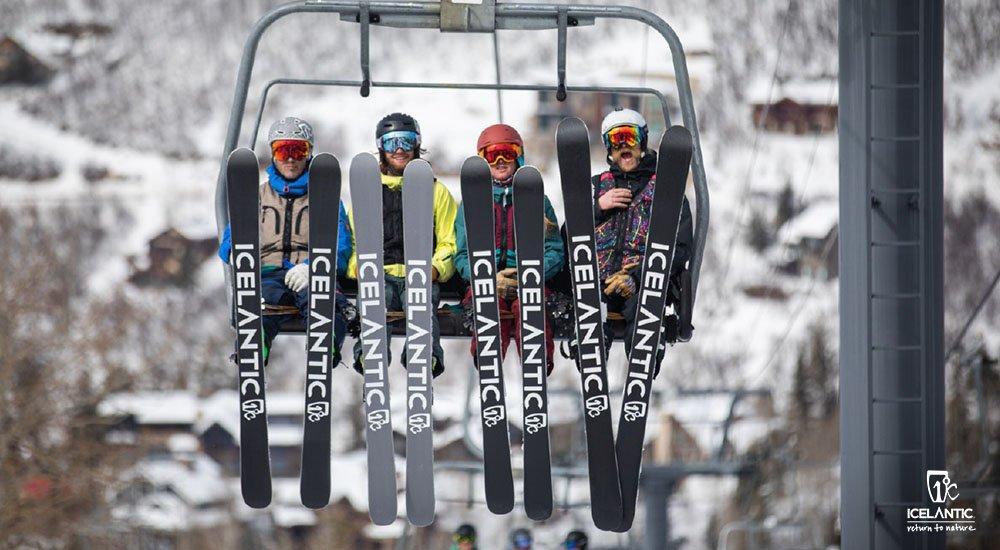 a group of 4 skiers going up a ski lift