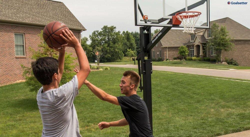 two players shooting hoops in their driveway