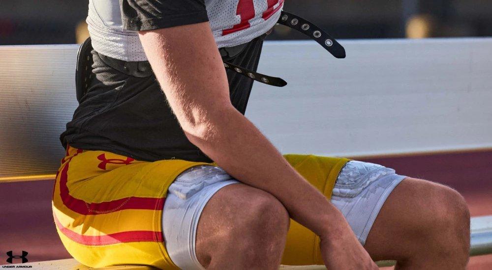 a player wearing a football girdle while on the sidelines at practice