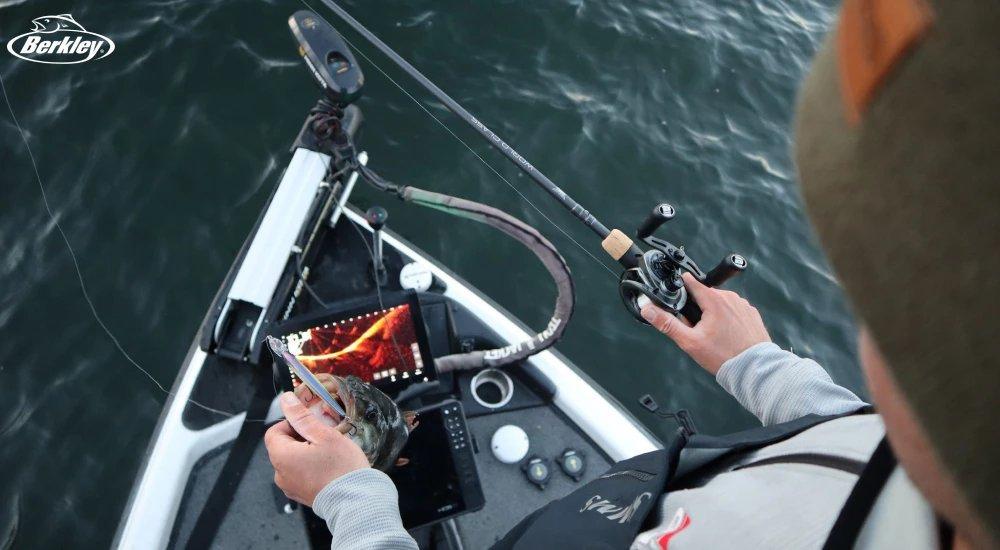 an angler holding a fish that uses a forward facing sonar bait