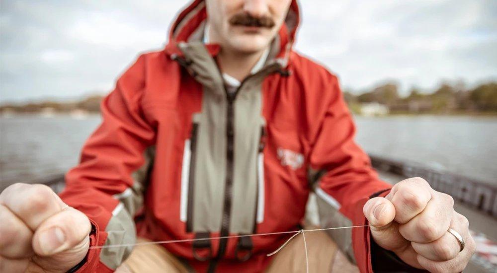 an angler tying a fishing line on the boat