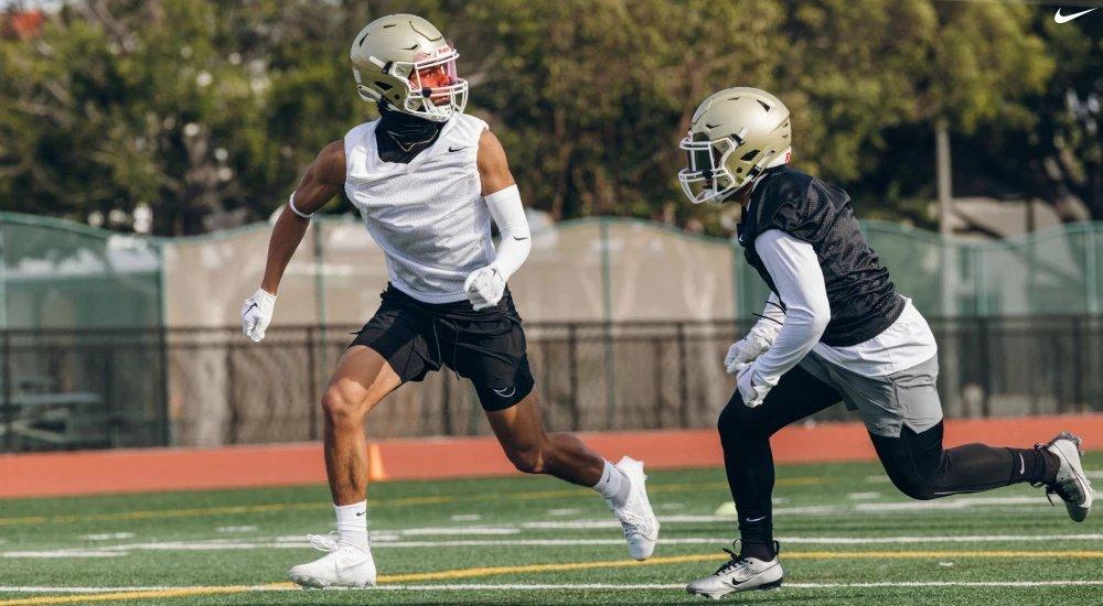 two players practicing football while wearing football cleats