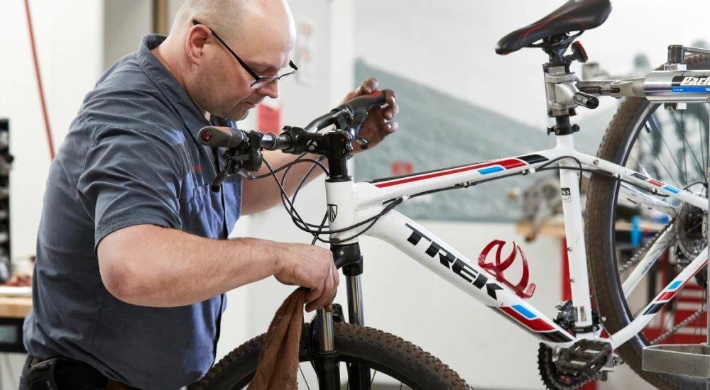 a man working on a Trek bike at the SCHEELS bike shop
