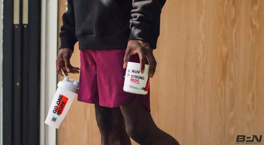 a man holding preworkout at the gym