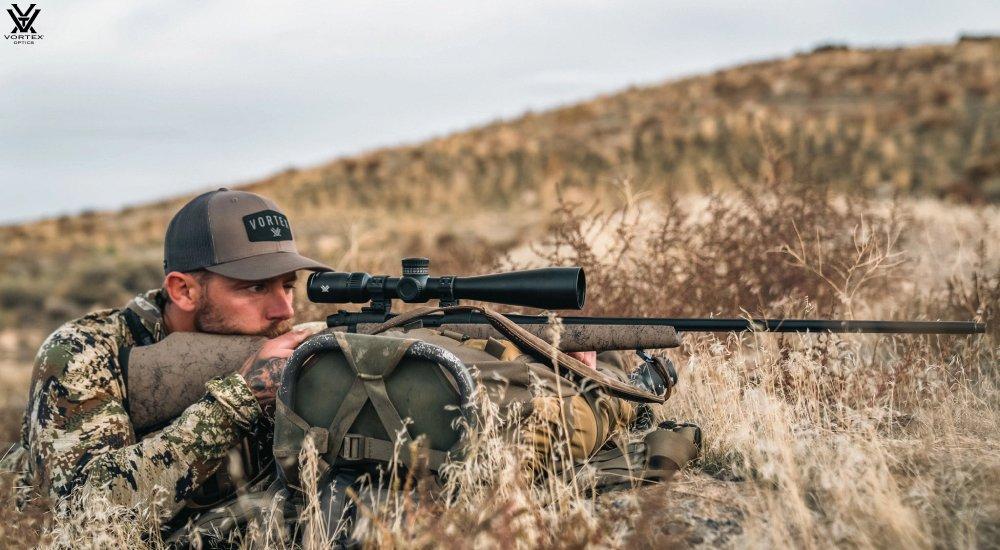 a man using a rifle scope when hunting