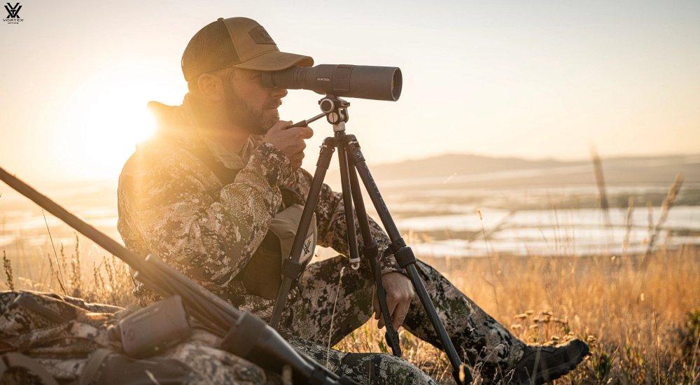 a hunter using a spotting scope in the field