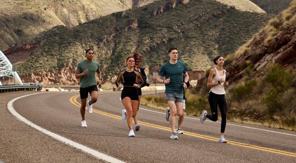 a group of Scheels Experts running on a road going up a hill