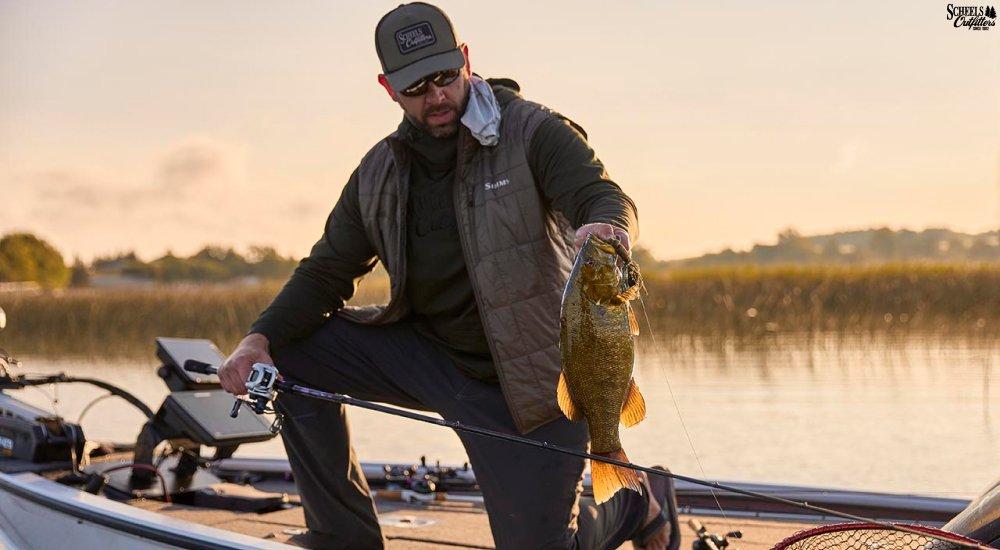an angler pulling a bass out of the water