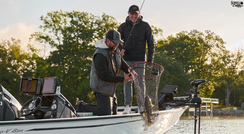 two anglers on a boat landing a fish