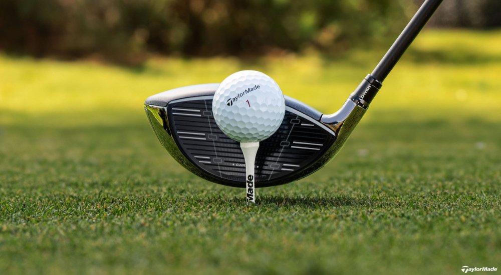 a taylormade golf ball on a tee with a driver behind it
