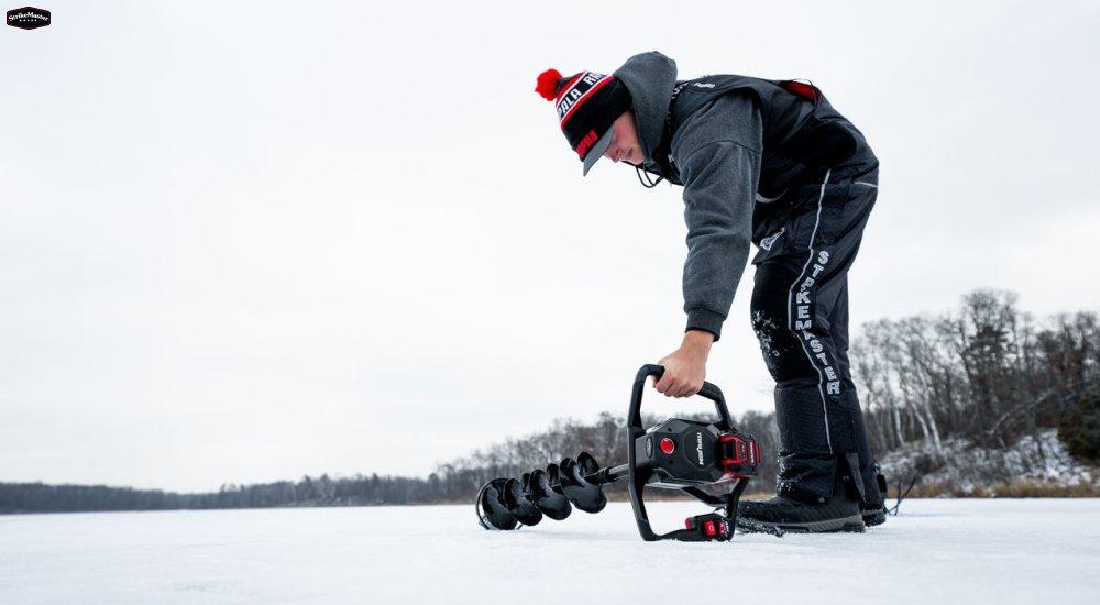 a man picking up an ice auger to drill a hole