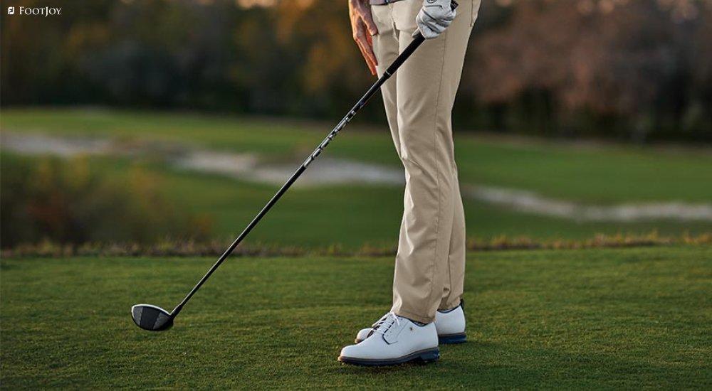 a man wearing a pair of FootJoy golf shoes on the course