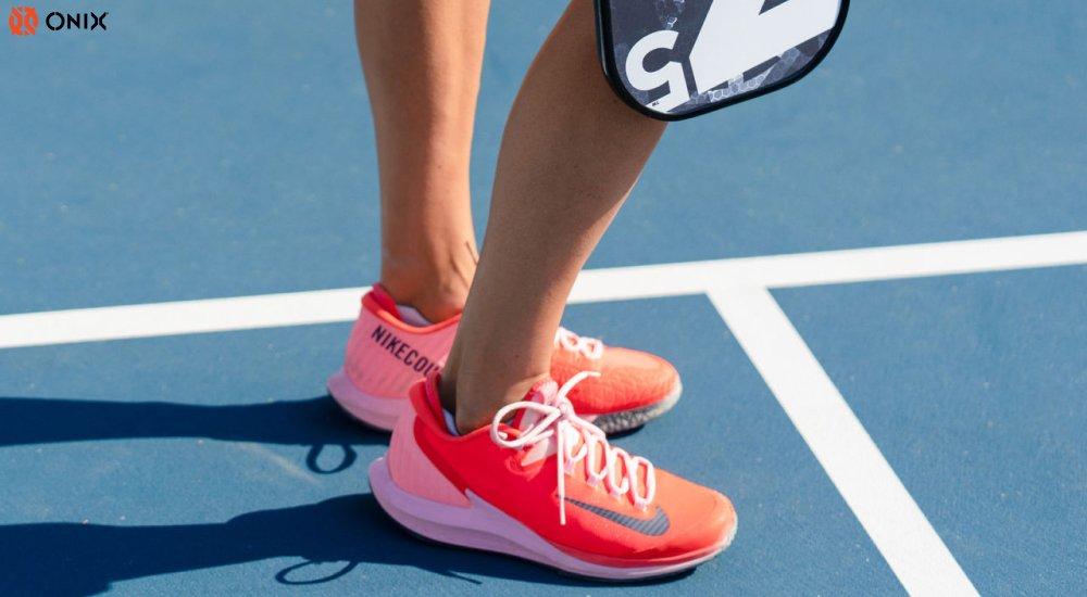 a female pickleball player wearing Nike pickleball shoes on the court