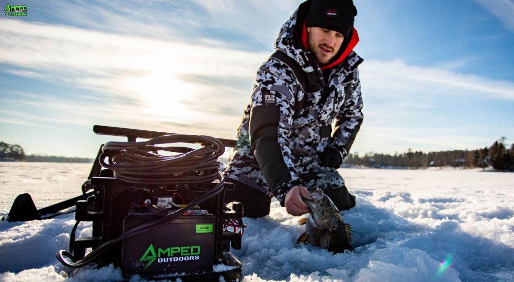 an ice angler using a fish finder powered by an amped outdoors battery