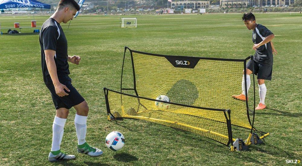 two players using a rebounder when training for soccer