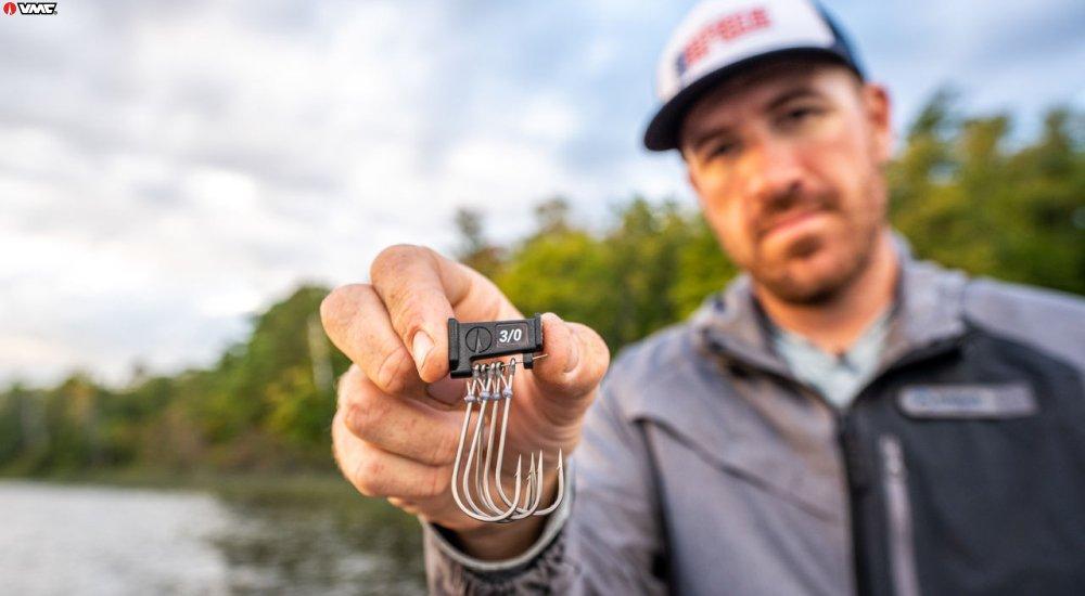 an angler holding up fishing hooks that are 3/0 in size
