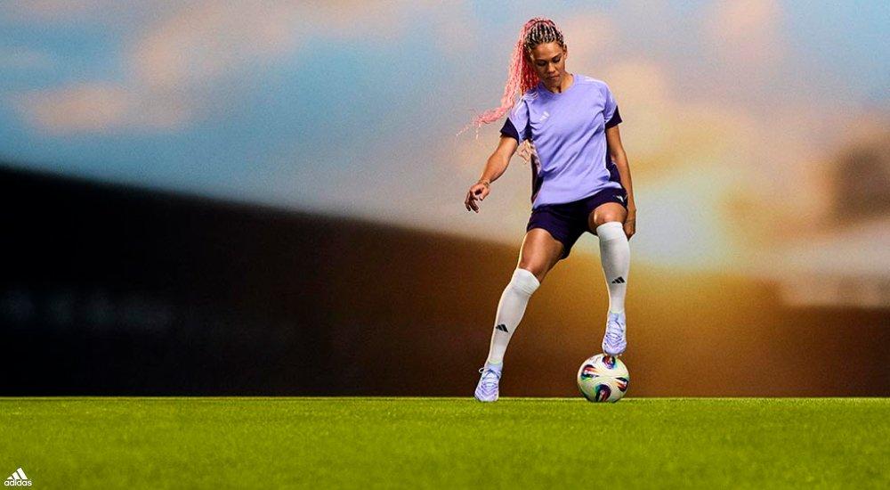 a girl kicking a soccer ball
