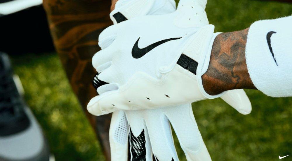 a football player wearing a pair of football gloves on the bench