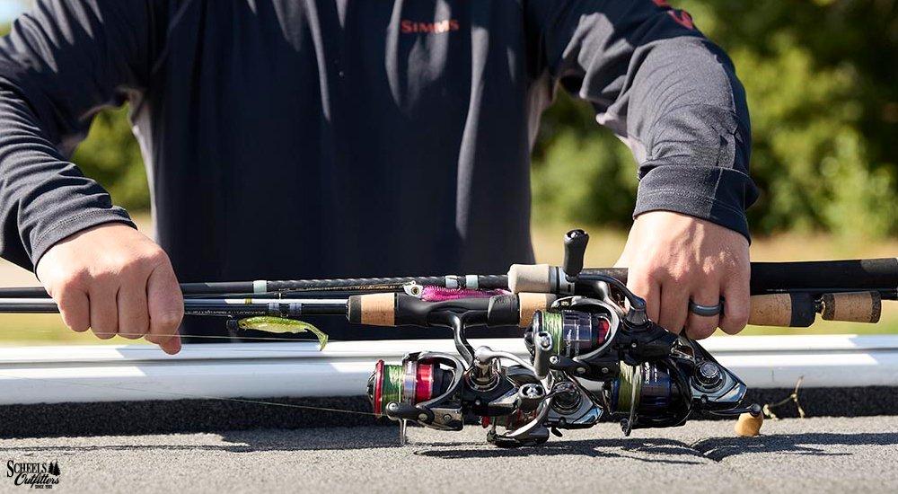 an angler holding a few spinning reels