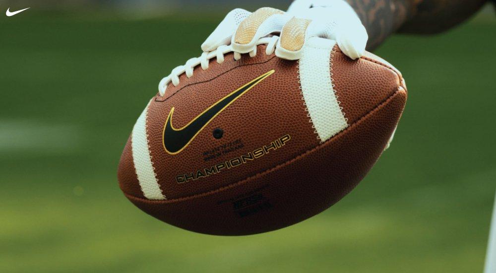 a player holding a Nike football at practice