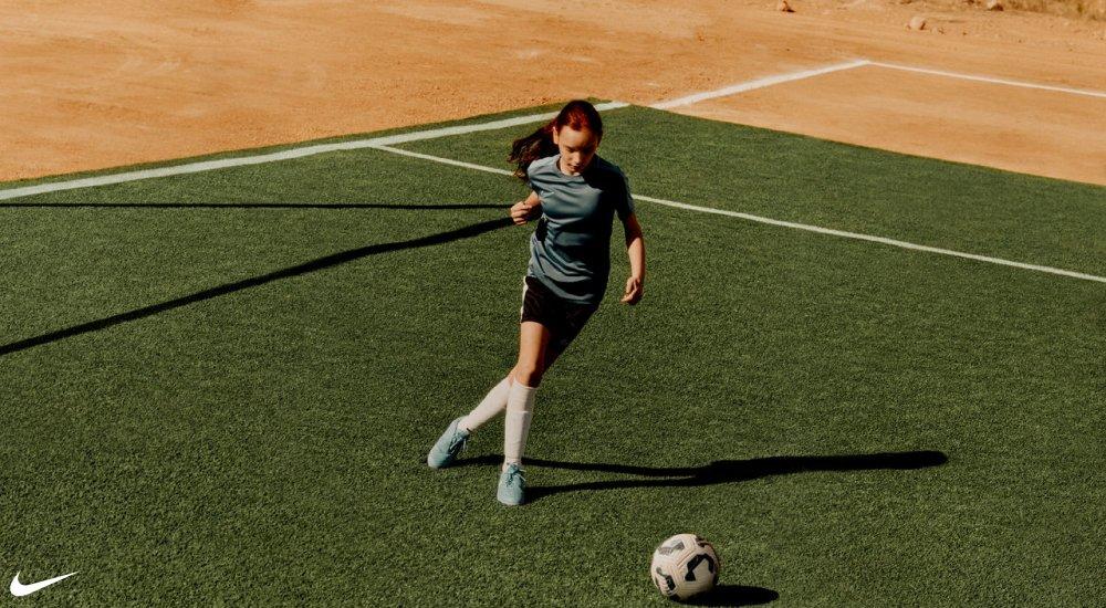 a girl running on the pitch wearing soccer gear