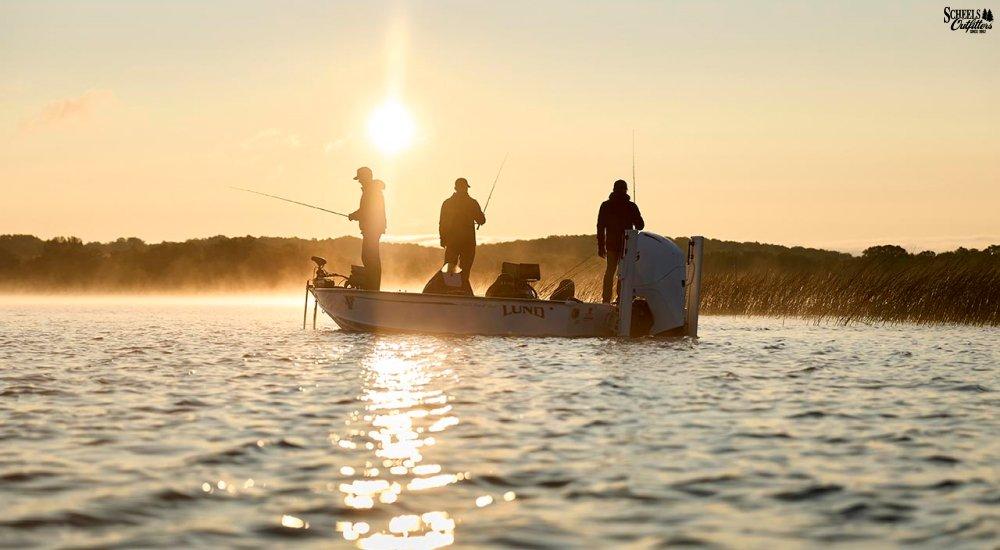 three anglers on the boat fishing at sunset