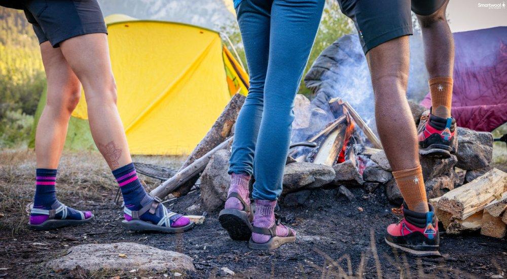 three people wearing smartwool socks when camping