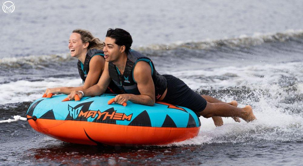 two people laying down on a towable tube that's pulled behind a boat