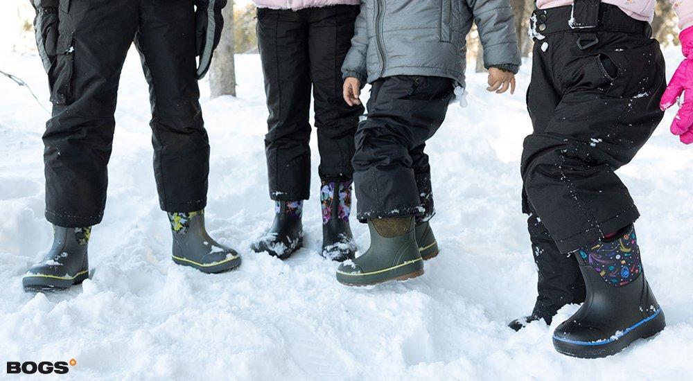 four kids wearing Bogs boots in the snow