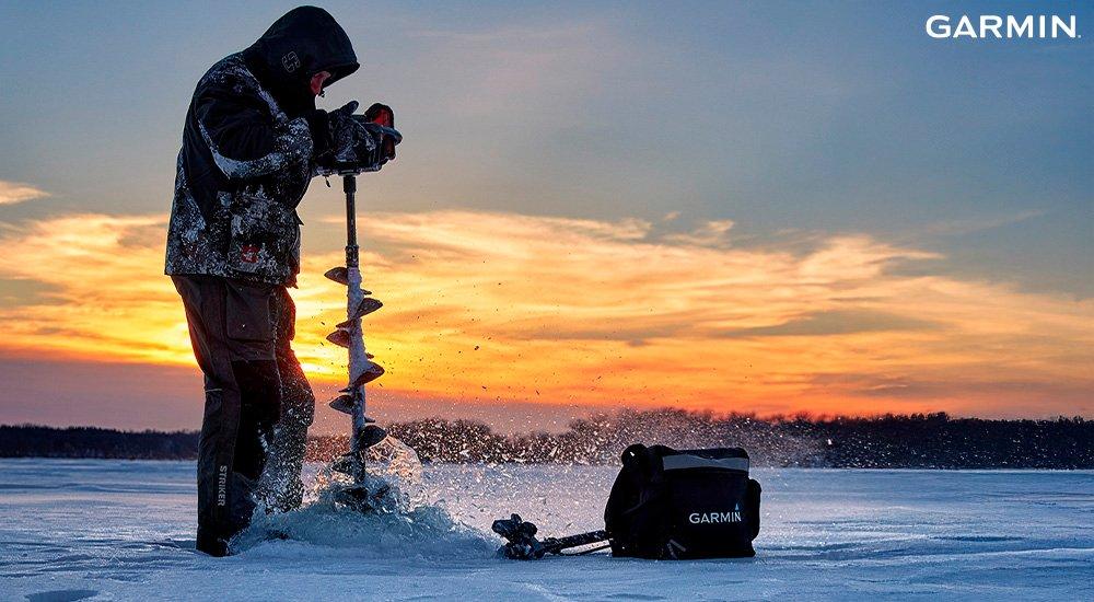 ice fisher using an auger to drill into the ice