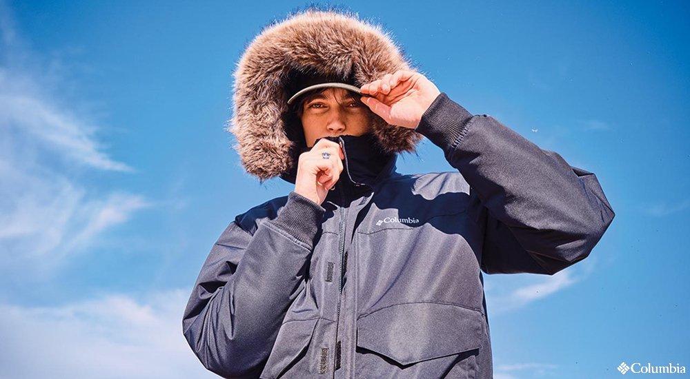 person wearing a black jacket with their fur hood up