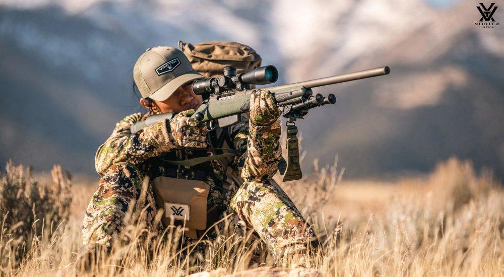a hunter using a Vortex rifle scope when hunting