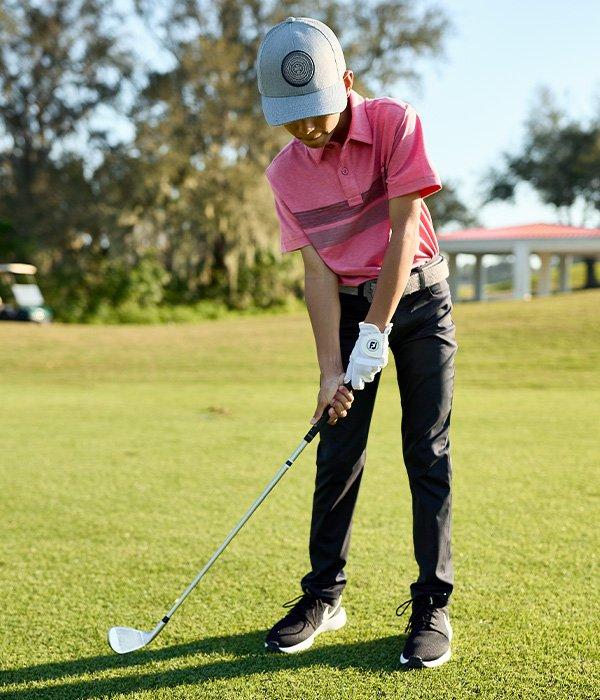 Lifestyle image of boy modeling golf gear