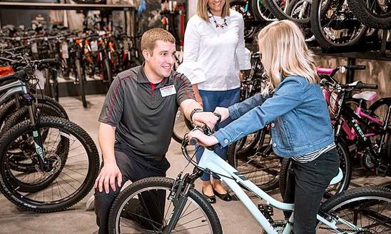 employee helping customer with a bike