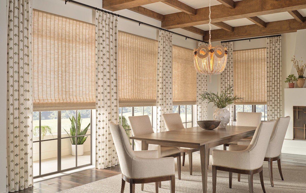 a dining room with large windows and custom blinds and drapes