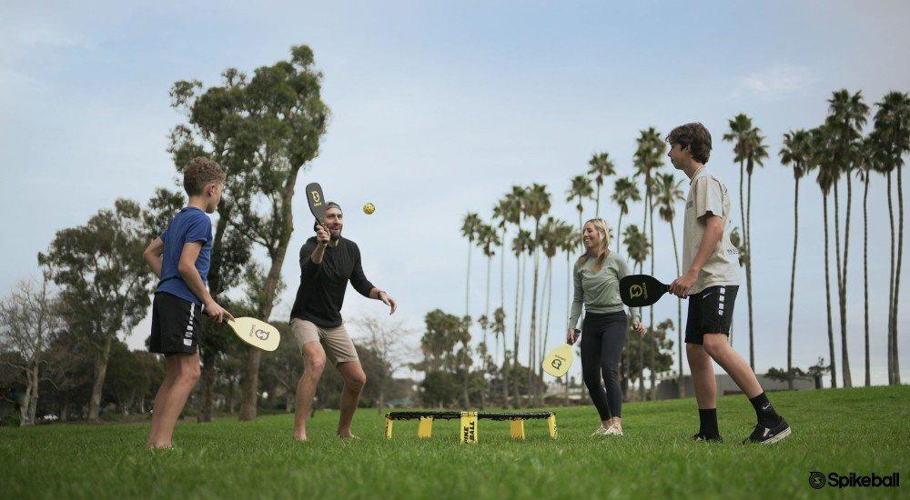 a family playing spikeball in the park 