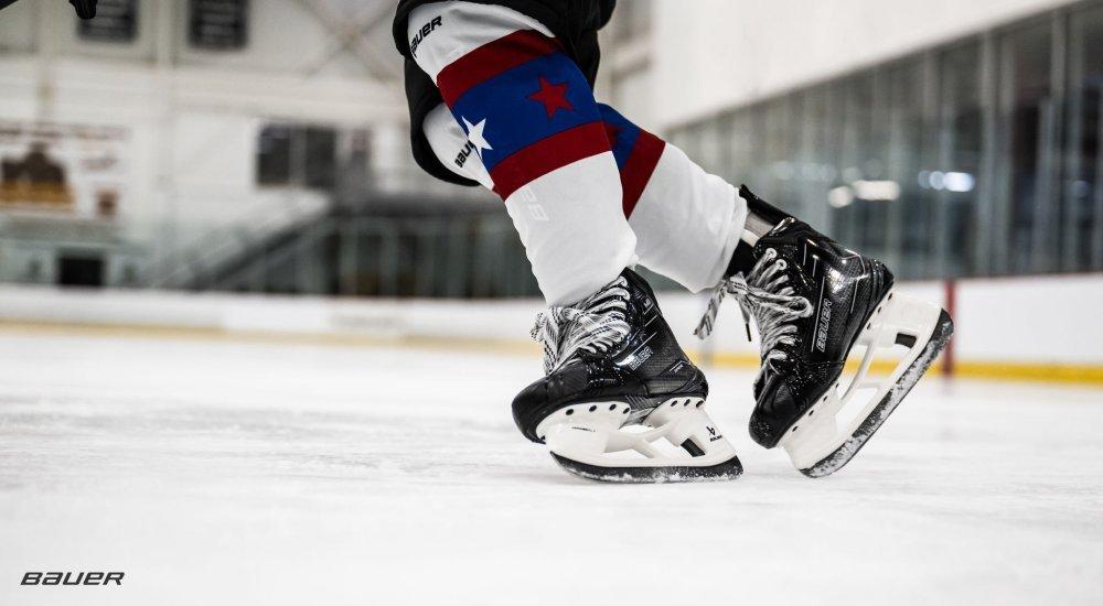 a hockey player skating on the rink with bauer skates